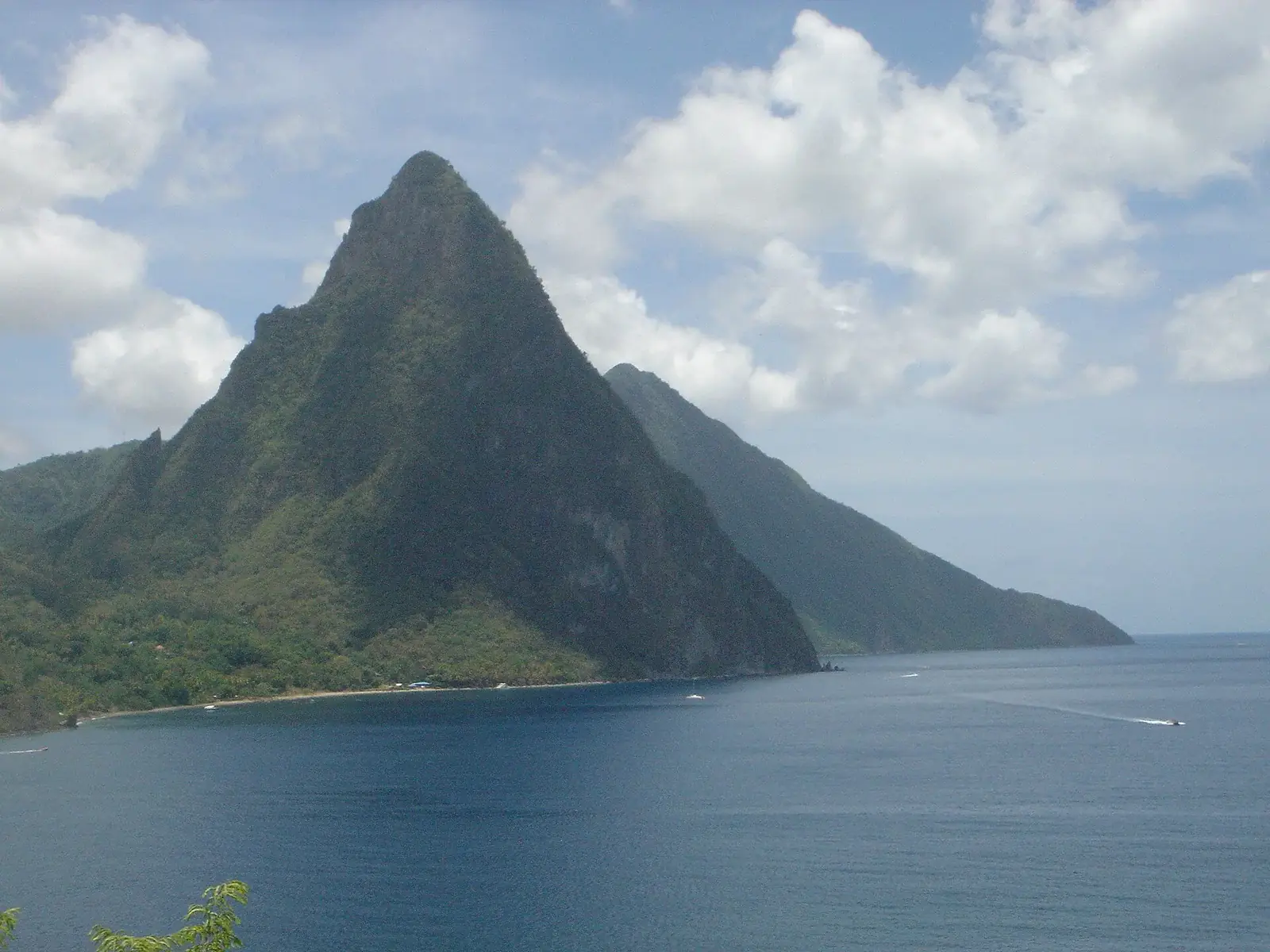 An infinity pool with a Caribbean sea and mountain ridge at dusk on St. Lucia.